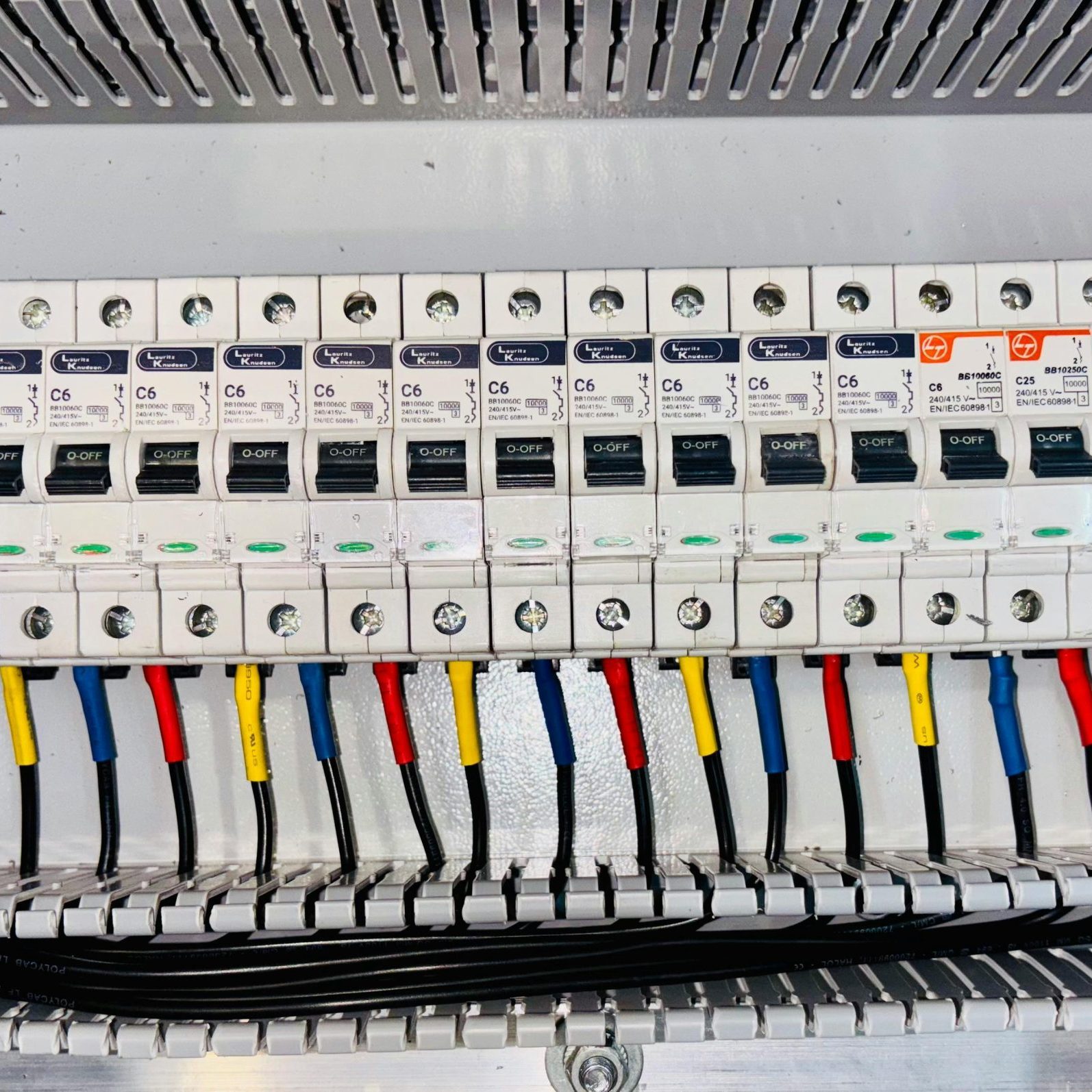 Close-up of an organized circuit breaker panel featuring color-coded electrical wiring.