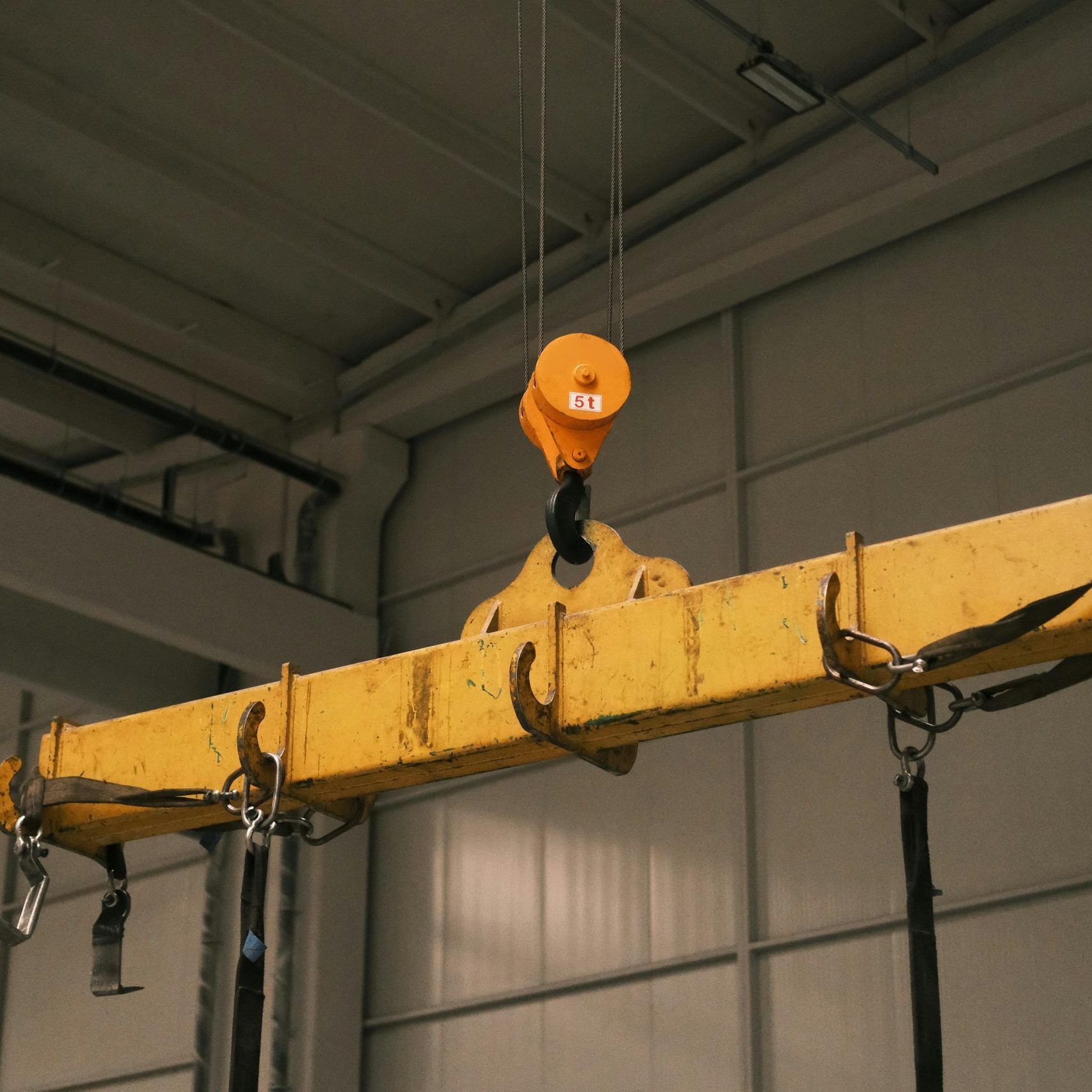 Close-up of a yellow industrial crane used in manufacturing, highlighting strength and machinery.